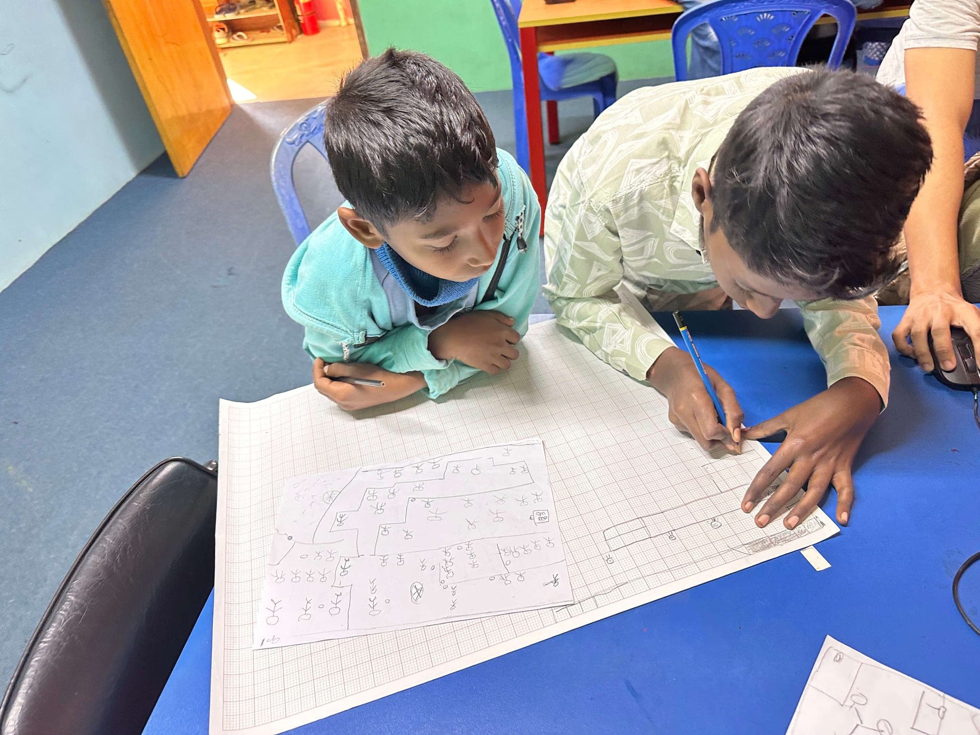 Students designing a game level on graph paper